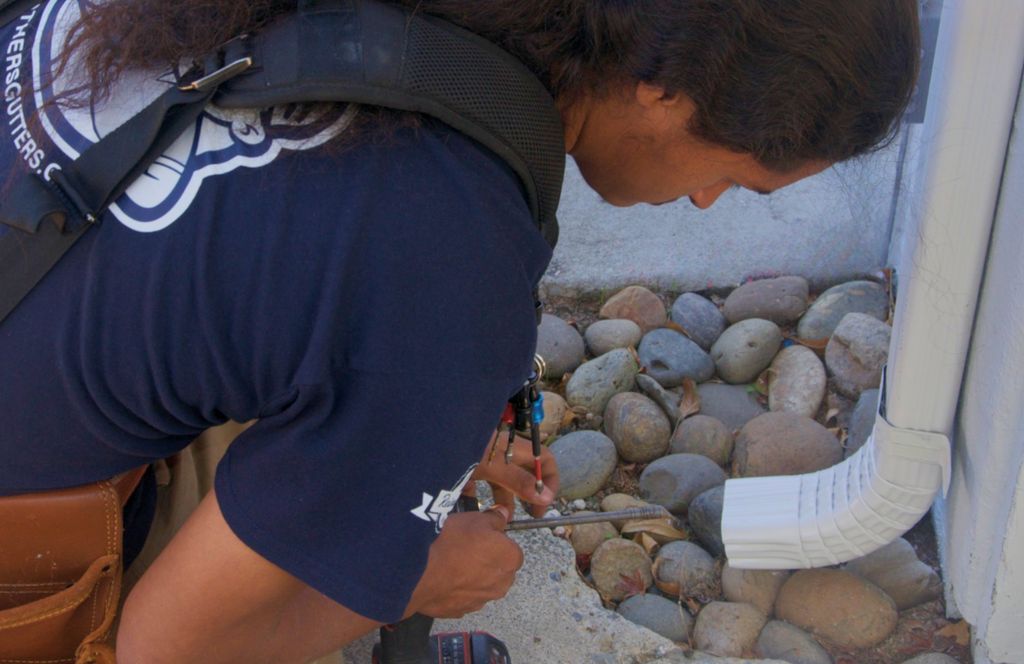 Setting a downspout outlet over a rock drainage bed