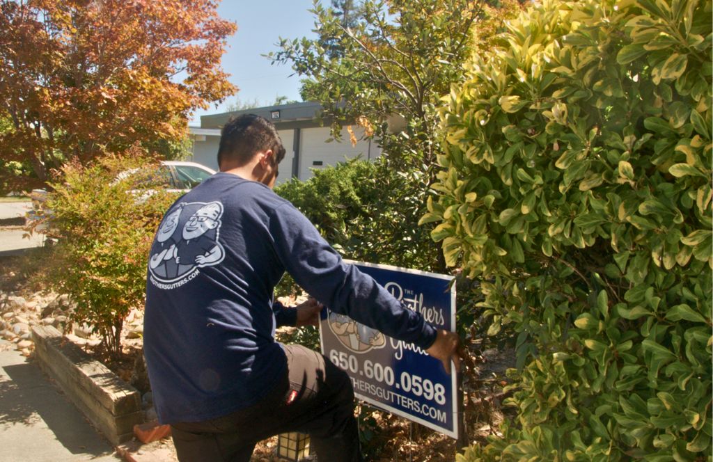 Setting a Brothers Gutters yard sign at a Peninsula job