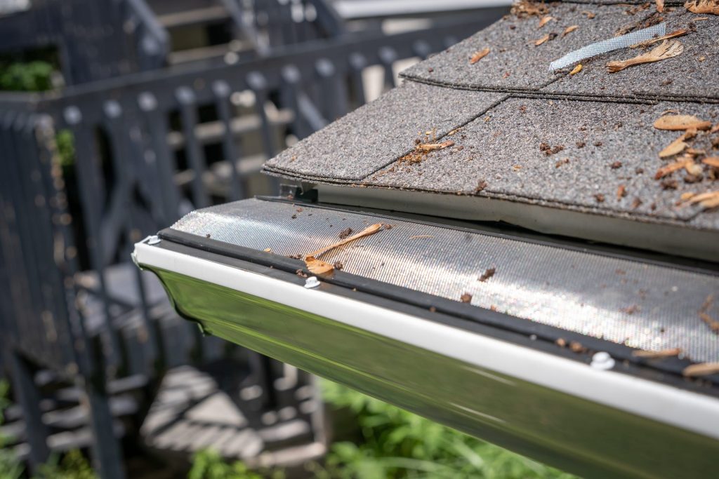 A gutter packed with leaves and roof debris