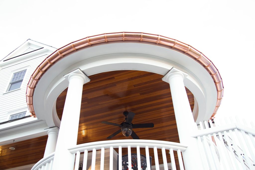 A curved copper gutter over a rounded front entry