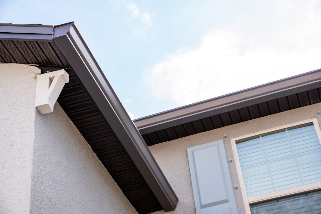 Brown gutters on a tan stucco home