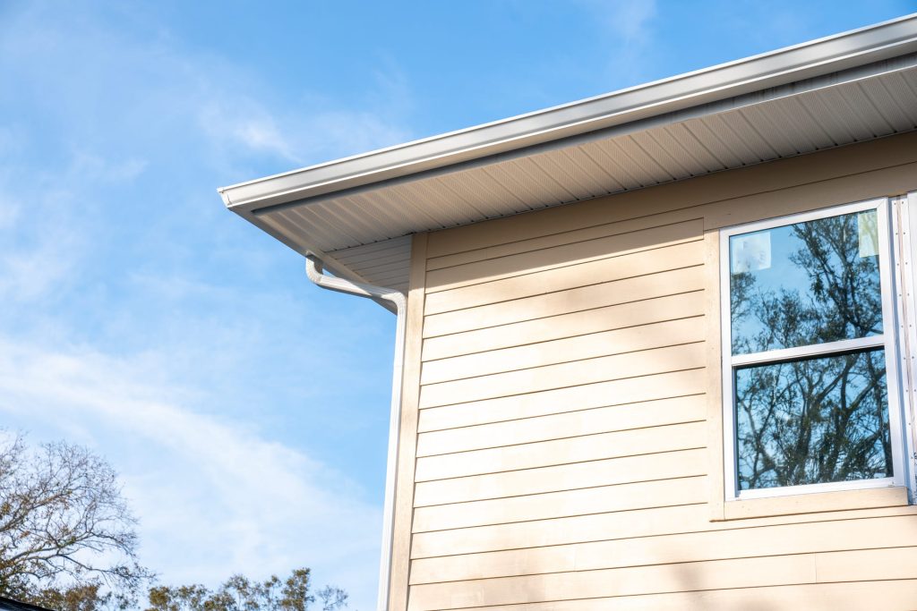 White seamless gutters along a sided home
